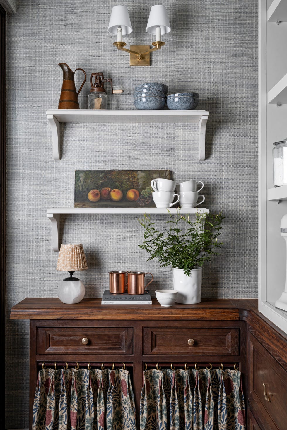 velfylte hyller tvers overfor vaskerommet, en walk in pantry holder små apparater og kjøkkenutstyr fra wayfair innen rekkevidde. Faste nedre hyller er panelt med keiserstein, mens de øvre hyllene er justerbare