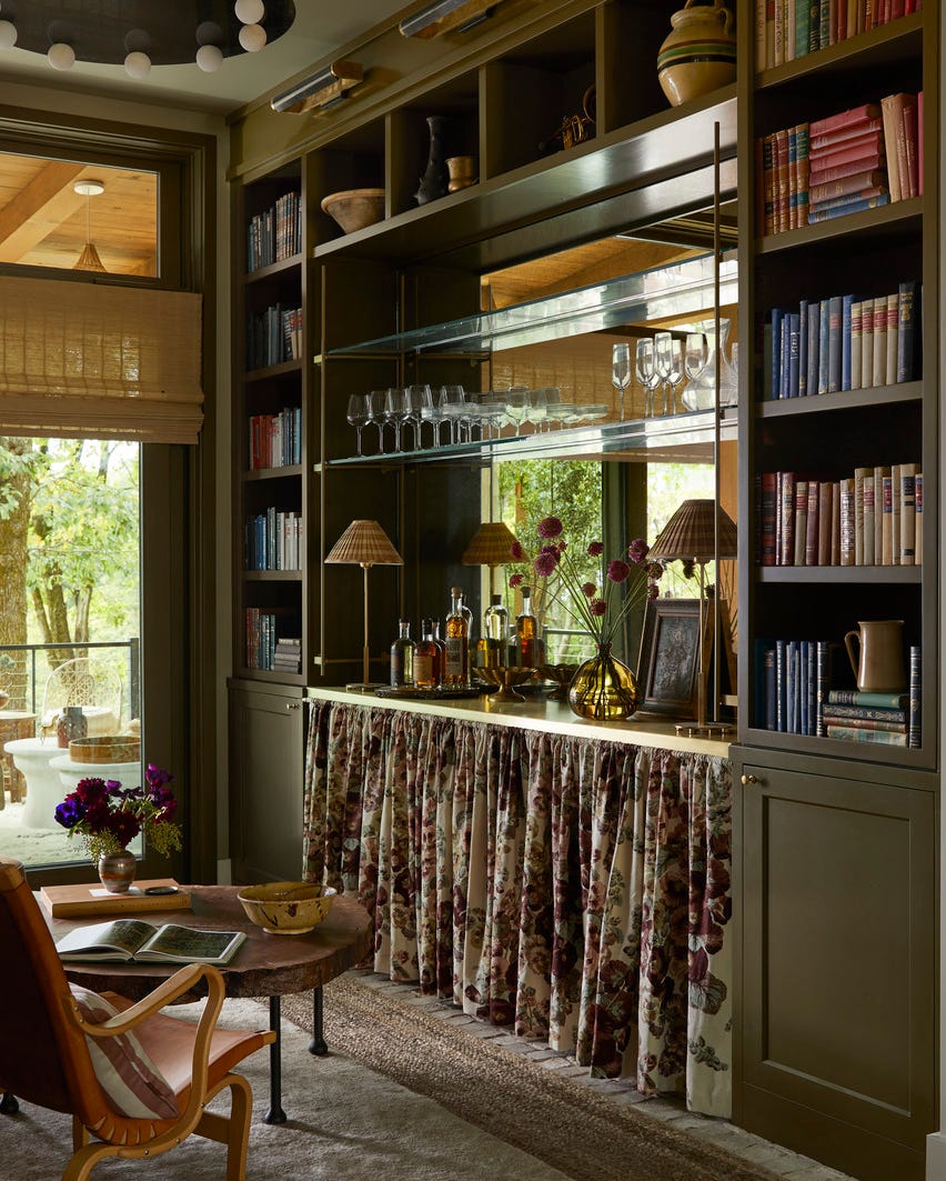 lesesal anne mcdonald design annemcdonalddesign intimt, koselig tilfluktssted, tilpasset fresing, luksuriøs ensomhet, antikk speil og messinghyllebraketter fra arkitektonisk gitter, flytende hyller, den nedre halvdelen av den innebygde er kledd med et blomsterskjørt, som myker opp den boksede arkitekturen petite rom taktile elementer, som en midcentury stol, Kalksteinskonsoll fra 1970-tallet og silkemykt geitehårteppe oppfordrer gjestene til å krysse terskelen for å toppe det hele. En visuell komfort lysekrone med alabastkuler tilfører et snev av vintage-glamour over hodet som balanserer det harde og myke her handlet om en kuratert blanding av teksturer hylle maskinvarebraketter og kafé gardinstang arkitektonisk gitter belysning visuell komfort co nyanser hunter douglas draperi clarence hustepper safar topp, fiberverk bunn hele hjemmet 2024 årets energieffektive hjem er i det bevaringsorienterte fellesskapet av sprout, som ligger i et privat naturreservat i hendersonville, nord-carolina