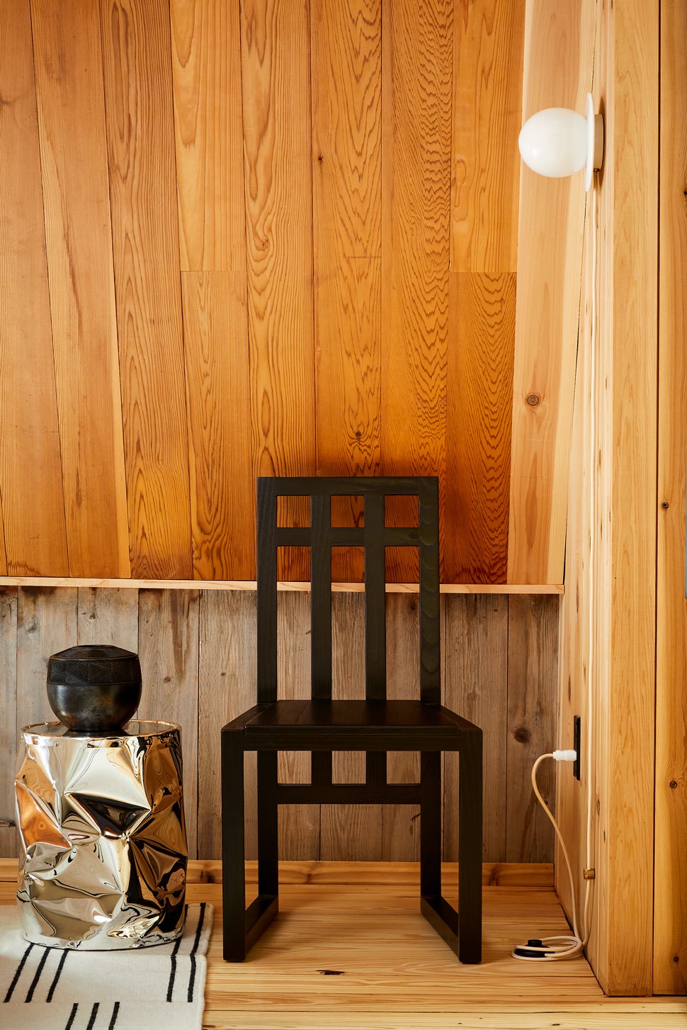 Minimalistisk hjørne av et rom med sidebord og vegglampe Minimalistisk hjørne av et rom med sidebord og vegglampe