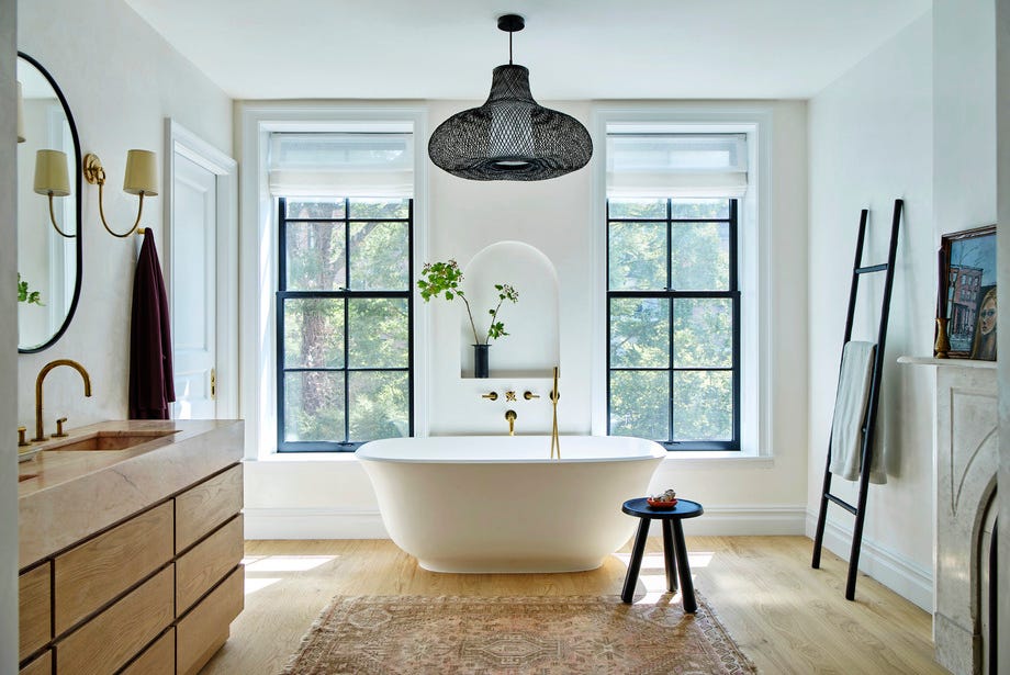 A -rched -innsatsen over Victoria Albert -karet gjenspeiler den buede inngangspartiet som fører til dette badet av Brownstone Boys i en 1899 Brooklyn Home Pendant Global Lighting