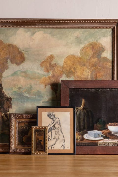 En samling av innrammede kunstverk som vises på en treoverflate
