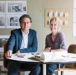 Arkitekter som diskuterer designplaner med en modell på bordet