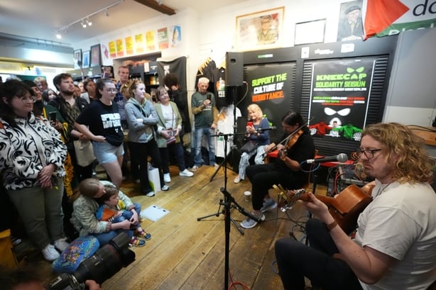 Ispini Na Heideann spiller pÃ¥ en musikkÃ¸kt som er iscenesatt pÃ¥ Connolly Books i Dublin's Temple Bar -omrÃ¥det for Ã¥ vise solidaritet for Knecaps Liam og O Hannaidh etter at han dukket opp ved Westminster Magistrates 'Court, i London, siktet for en terrorforbrytelse. 27-Ã¥ringen, av Belfast, som opptrer under S