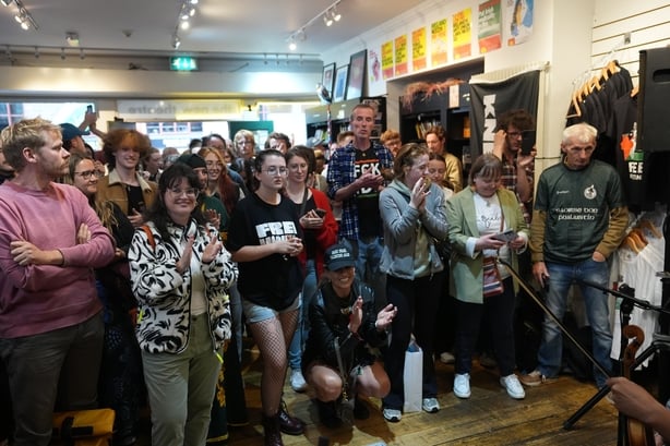 Folk deltar pÃ¥ en musikkÃ¸kt som er iscenesatt i Connolly Books i Dublin's Temple Bar -omrÃ¥det for Ã¥ vise solidaritet for Knecaps Liam og O Hannaidh etter at han dukket opp pÃ¥ Westminster Magistrates 'Court, i London, siktet for en terrorforbrytelse. 27-Ã¥ringen, av Belfast, som opptrer under scenenavnet Mo C