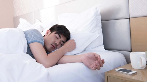 En mann som sover i en seng