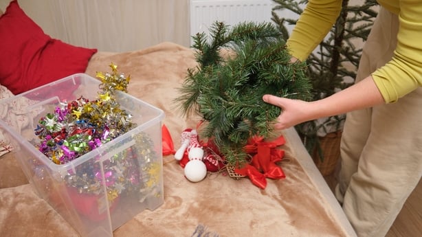 En kvinne som rydder bort julepynt