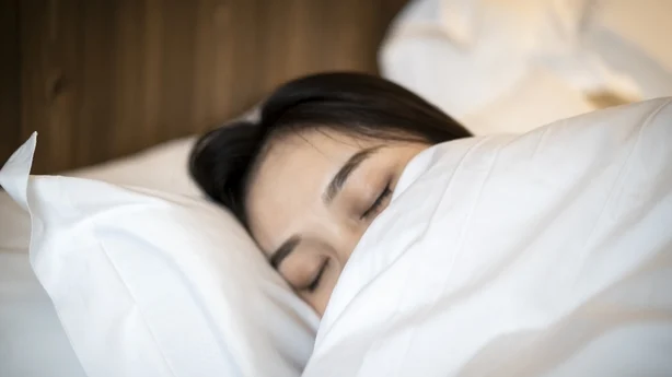 En ung asiatisk kvinne sover