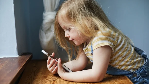 SmÃ¥barnsjente som bruker en smarttelefon