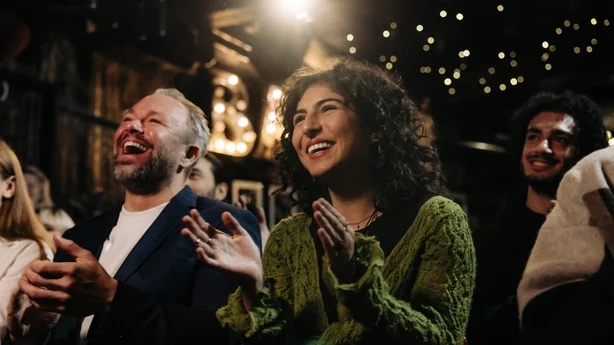 mann og kvinne ler av komedieshow