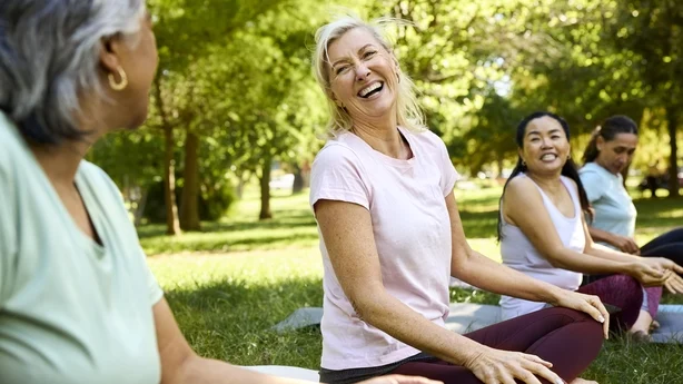 Glad kvinne nyter yoga med venner i parken