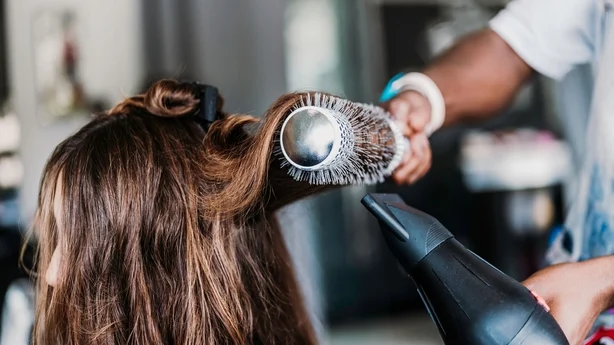 en person som føner hår