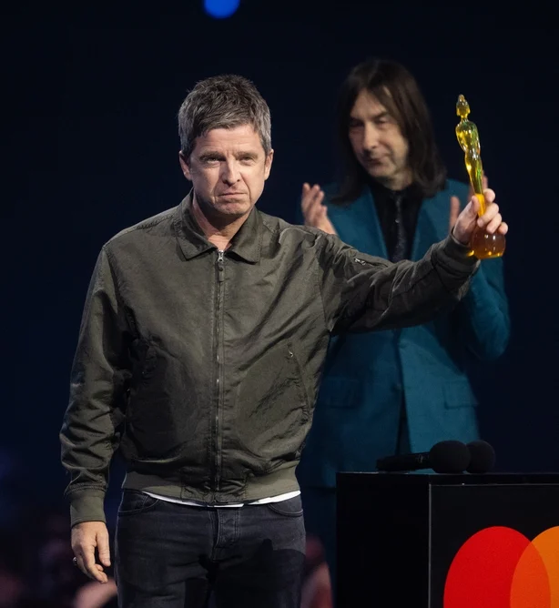   Noel Gallagher mottar prisen for Ã¥rets lÃ¥tskriver fra Bobby Gillespie under The BRIT Awards 2026