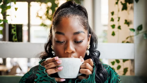 kvinne som drikker en kopp kaffe