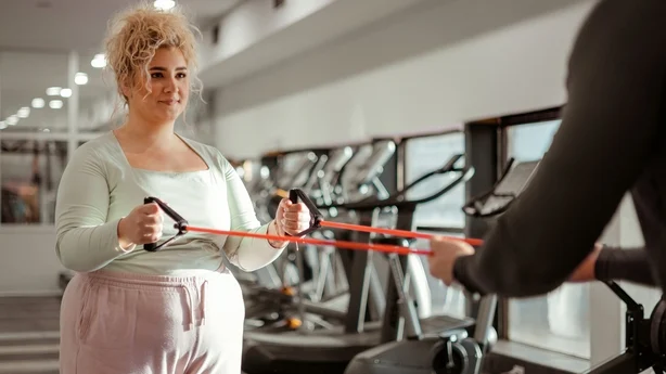 kvinne i treningsstudioet som trener med treningstrener