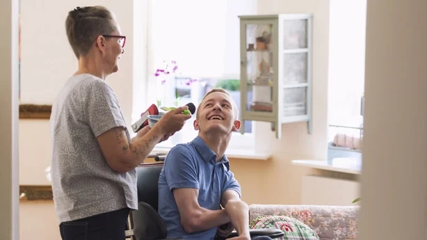 Ung fysisk svekket Cerebral Parese-pasient blir matet av sin mor.