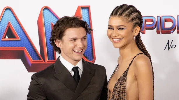 Tom Holland og Zendaya smiler mens de poserer for et bilde pÃ¥ den rÃ¸de lÃ¸peren
