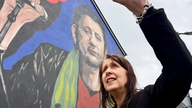 Siobhan MacGowan stÃ¥r foran et veggmaleri av broren Shane MacGowan