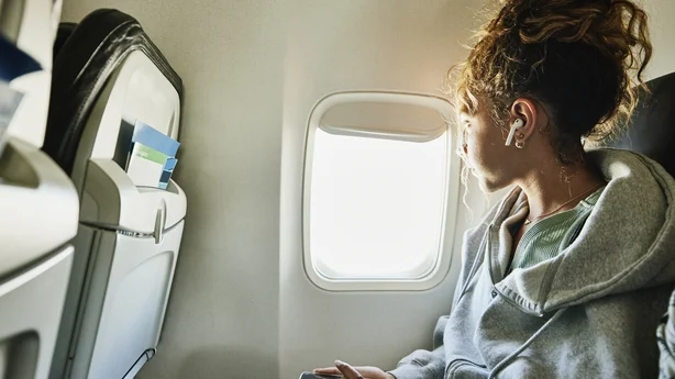 Middels bilde av jente som ser ut av vinduet på flyet