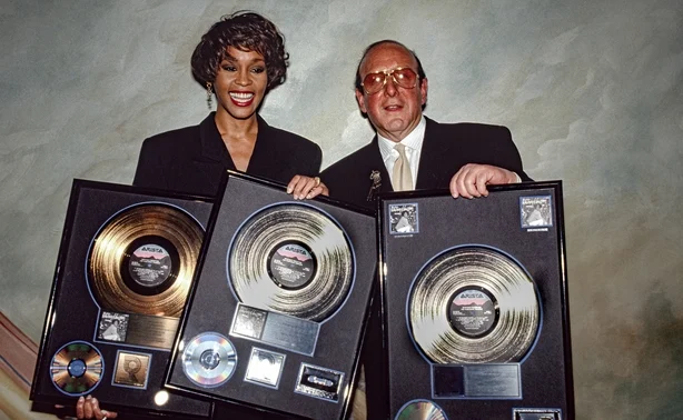 Whitney Houston mottar en plakett til minne om platinasalget av albumet I'm Your Baby Tonight fra den amerikanske musikksjefen og produsenten Clive Davis 10. desember 1990 i New York City, New York.