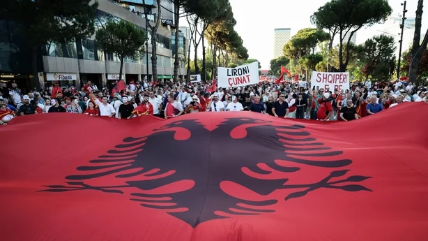 Demonstranter vifter med et gigantisk albansk flagg utenfor statsministerens kontor i løpet av den trettifemte dagen på rad med protester mot et foreslått utviklingsprosjekt for luksusturisme i Tirana, Albania, 4. juli 2026. (Foto: Vlasov Sulaj/NurPhoto)