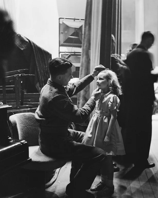 Petula Clark får en sjekk i siste øyeblikk fra sin far, underkorporal Leslie Clark, før hun går på scenen på BBCs Empire-bursdagsfest, desember 1942. (Foto: Fred Ramage/Keystone Features/Hulton Archive/Getty Images)