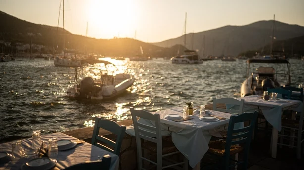 Bord dekkes på en restaurant ved vannet i byen Vathy på øya Ithaca. (Foto: Angelos Tzortzinis/AFP)
