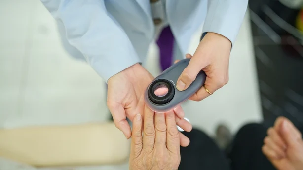Kvinnelig seniorpasient ved hudklinikken for neglepleie.