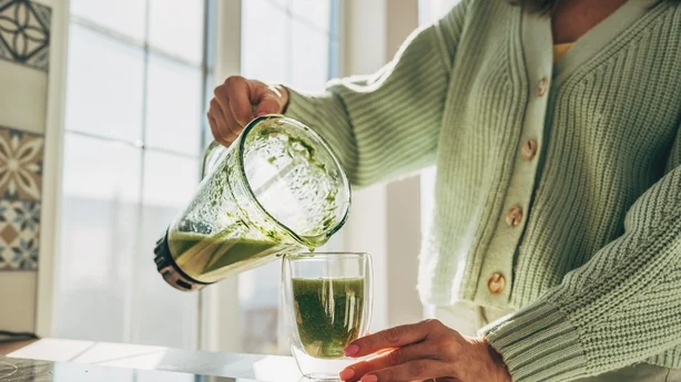 Ung kvinne lager detox-smoothie
