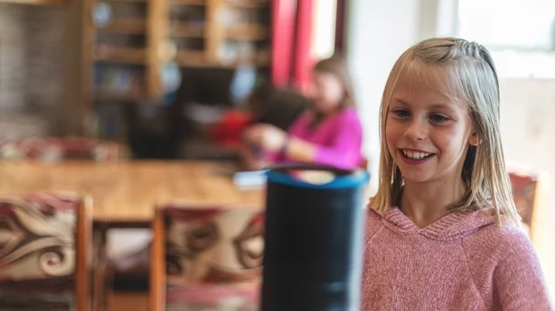ung jente som snakker til Alexa-maskinen