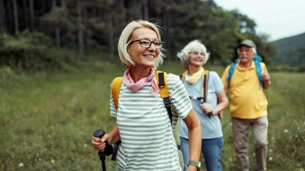 Moden kvinne nyter dagen i skogen med venner